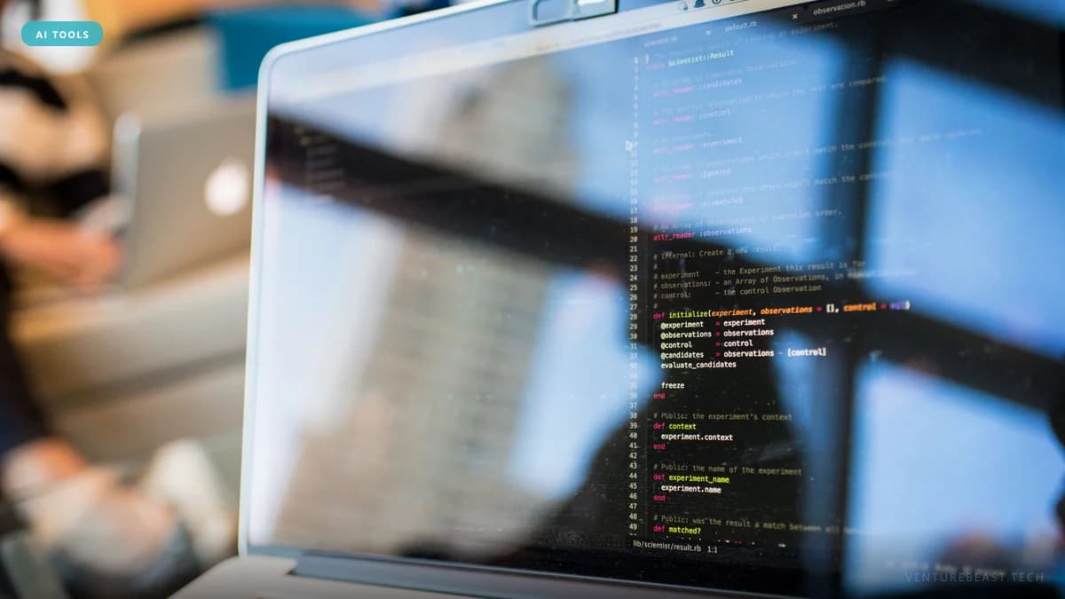 Close-up of a laptop screen showing code in a dark editor, with window reflections and a blurred coworker behind