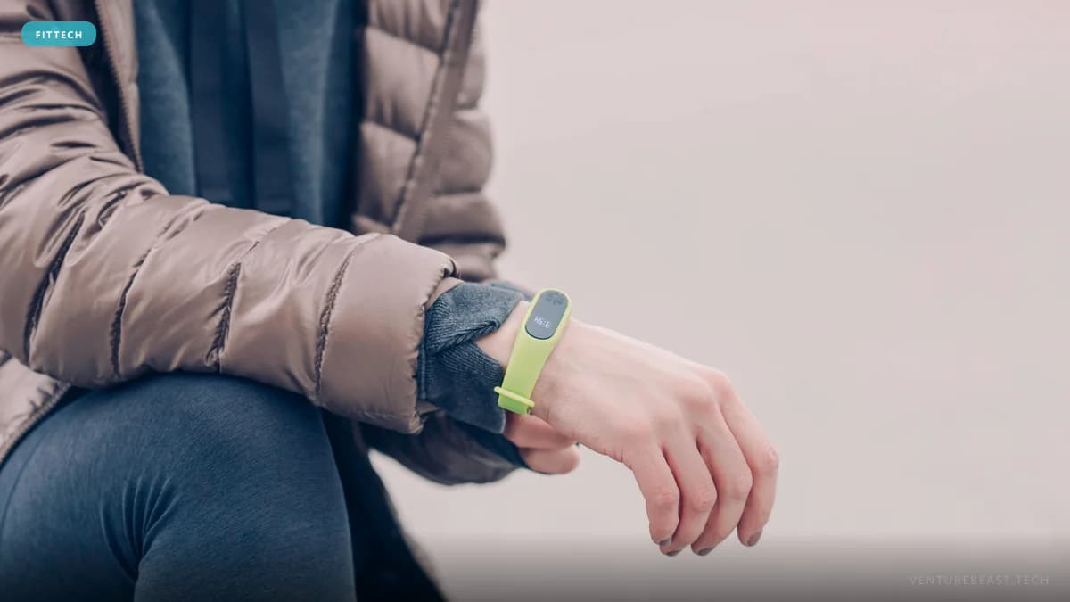 Close-up of a person in a puffer jacket wearing a lime-green fitness tracker band on their wrist